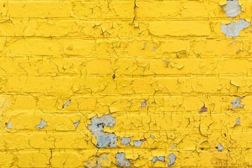 texture old brick wall painted yellow paint, peeling and crumbling paint on white bricks, abstract background