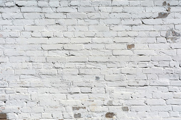 relief texture old brick wall painted with white paint, damages on the wall from the flow of water, abstract background