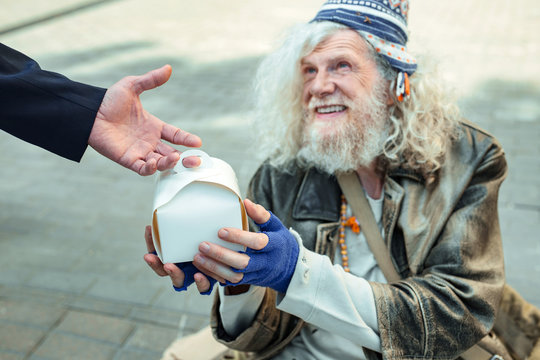 Hippy Man. Street Hippy Man Wearing Old Leather Jacket Getting Big Food Box From Local Charity Organization