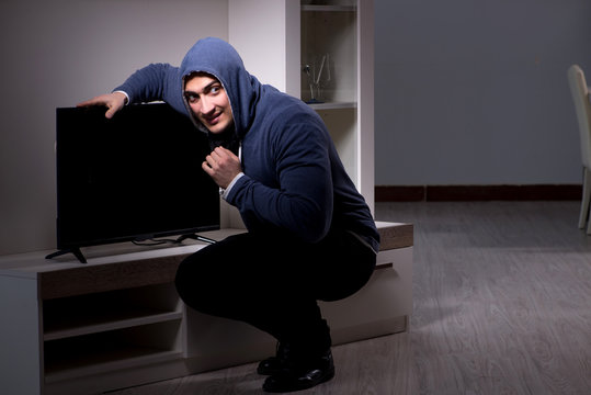 Burglar thief stealing tv from apartment house