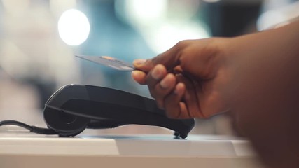 Close up hand african american man use credit card terminal store machine hand commerce shopping money technology paying business typing buy transaction pay market cashier customer banking - Powered by Adobe