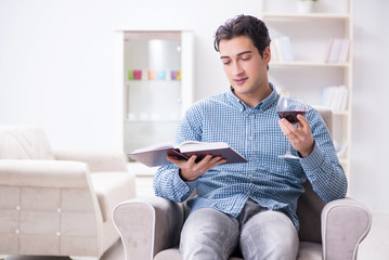 Young man drinking wine at home