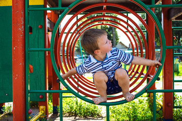 Little boy playing on the playground.  The child is in a circle.