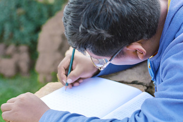 Illiterate native american man learning to write in the countryside. 