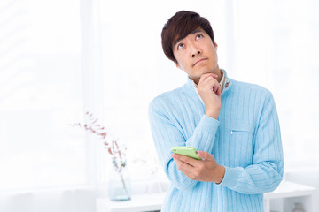 スマホを見るミドル男性　考える