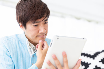 タブレットを見るミドル男性　考える