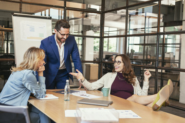 Break from work. Happy three colleagues having meeting and laughing