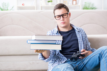 Young student trying to balance studying and playing games