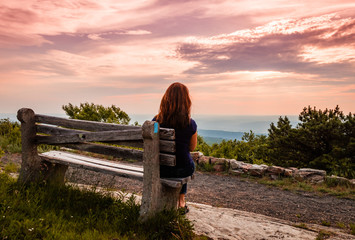 A lone bench faces the mountains under a stormy sunset at High Point State Park, the top of NJ