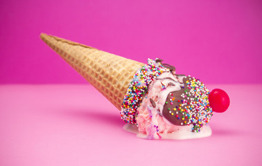 Melting Ice Cream in a Cone with Chocolate and a Cherry on Top