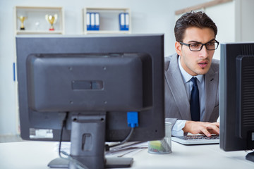 Businessman sitting in front of many screens