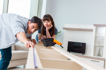 Young family assembling furniture at new house