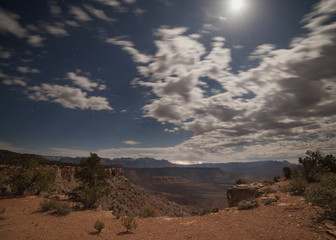 Fototapeta na wymiar Stars and moon beams light the rim of Smith's Mesa as lightning strikes east of Zion National park. 