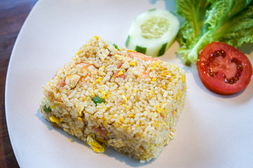 Seafood shrimp fried rice with lettuce, tomato slice, and cucumber vegetable