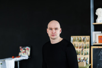 Portrait of the bald man in a creative workshop
