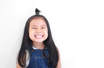 Asian children cute or kid girl and kindergarten student happy smile white teeth and laugh with wear dungarees jean for fashion on white background with space isolated - Powered by Adobe