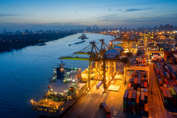 Aerial view of business port with shore crane loading container in container ship in import/export and business logistics with crane and shipping port cargo.International port concept.