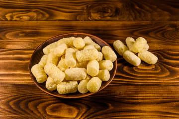 Ceramic plate with corn sticks on wooden table