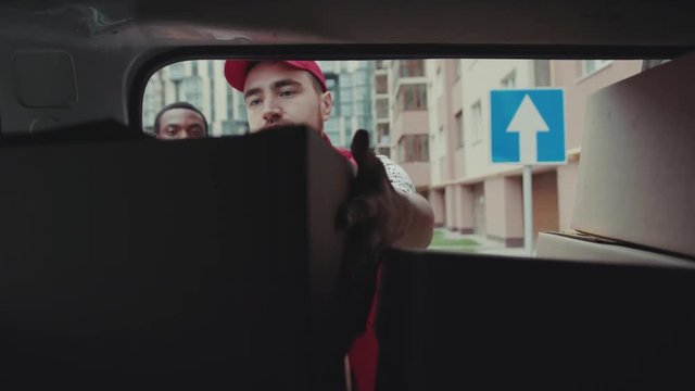 courier African American open car gives a parce to a man after signing on delivery device cardboard technology box order post postal service device sunny beard covered load logistic mailman
