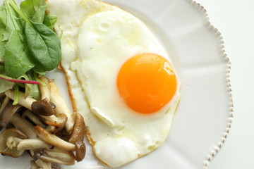 Sunny side up fried egg served with shimeji mushroom sauteed
