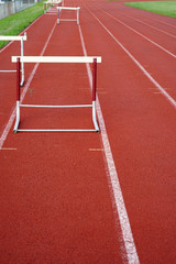 hurdles in a row on red sport field