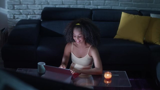Young Latina Woman Typing Message on Laptop At Night