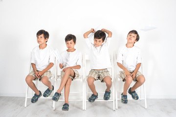 The boy is sitting on a chair and waiting for his turn.  He is very impatient, he is suffering, but...