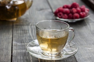Raspberry and green tea from a linden on a wooden table