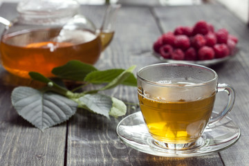 Raspberry and green tea from a linden on a wooden table