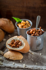 Tasty and homemade bun with mushrooms on old wooden table