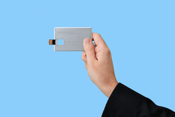 Card USB flash memory on hand with isolated blue background