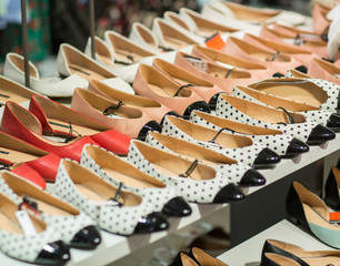 Different shoes in shop- Shopping, fashion, style and people concept