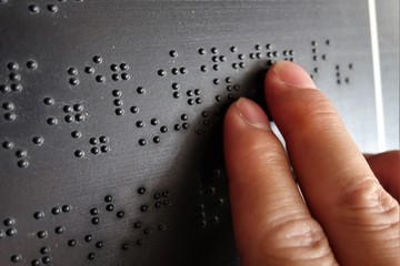 Close up of male hand reading braille text
 - obrazy, fototapety, plakaty