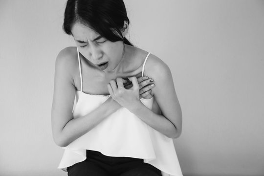 Young Asian Woman Having Heart Attack / Heart Burn In Black And White Tone - Healthcare And Medical Concept