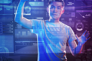 Favorite job. Experienced young programmer touching a transparent screen with his two hands while working with a futuristic device