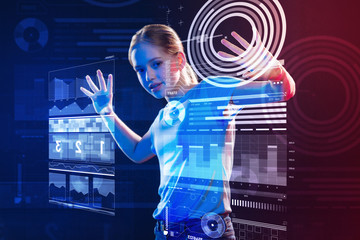 Clever schoolgirl. Smart schoolgirl looking excited and touching a transparent screen with two...