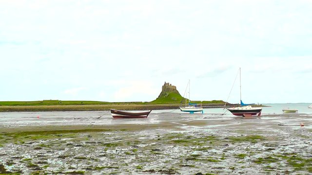 Yachts in front of Lindisfarne Castle, a 16th-century castle located on Holy Island, near Berwick-upon-Tweed, Northumberland, England.