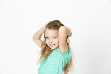 Fototapeta premium beautiful young girl is happy and dancing and posing in the studio in front of white background