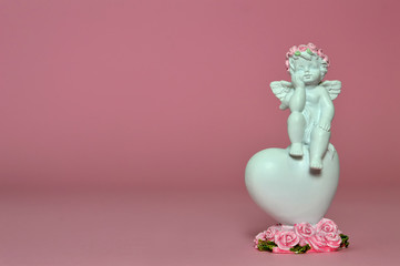 Angel and heart decoration on pink background with copy space. Love concept  