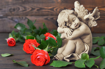 Guardian angel and roses on wooden background