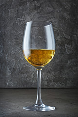 Glass with white wine for tasting in dark cellar