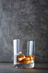 Strong alcoholic drink scotch whisky with ice cube in old fashion glass