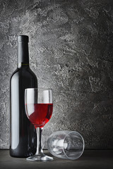 Red wine bottle and glasses for tasting in dark cellar