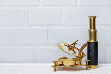 Old vintage retro compass and spyglass as accessories for styled journey with copy space