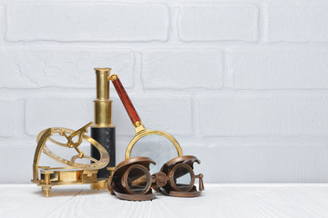 Old vintage retro compass, binoculars and spyglass as accessories for styled journey with copy space