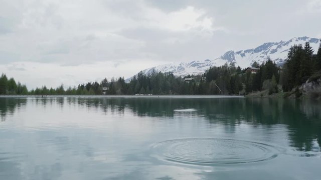 Rear view of a person doing ricochets on a lake in the alps