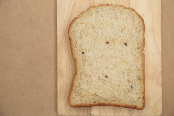 Whole grain bread on brown wood background.