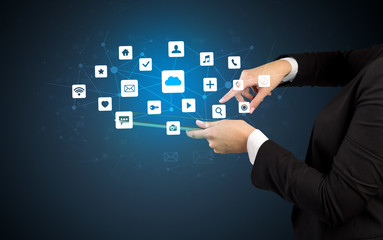 Female hand touching tablet with application icons above