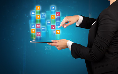 Female elegant hand holding tablet with colourful application icons