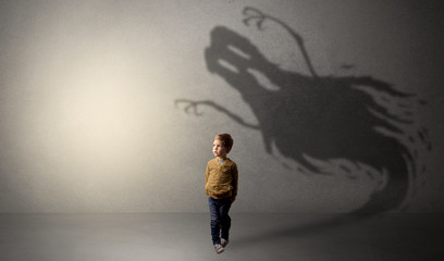 Scary ghost shadow in a dark empty room with a cute blond child
